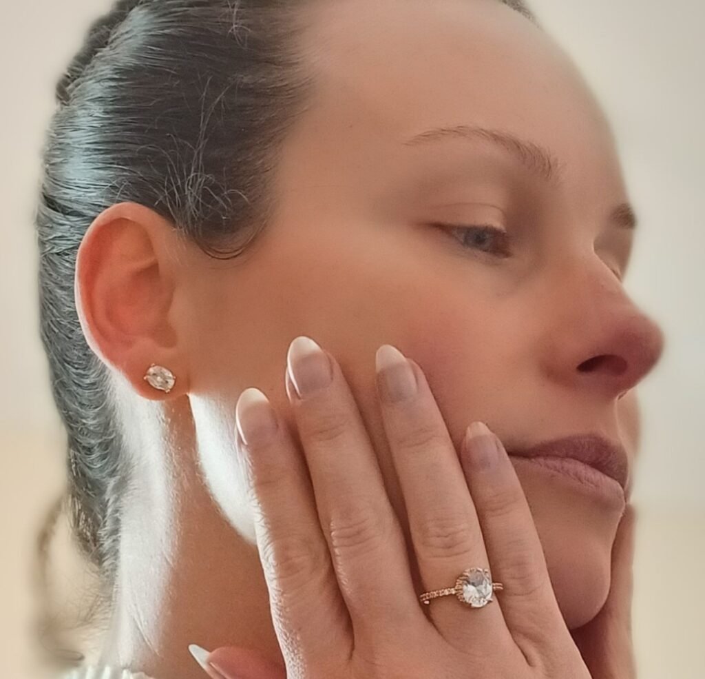 Woman gently touching her face with hands, representing sensitive skin and skin barrier care